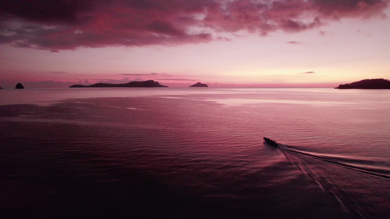 보트가 목적지 실루엣으로 가는 붉은 짙은 일몰