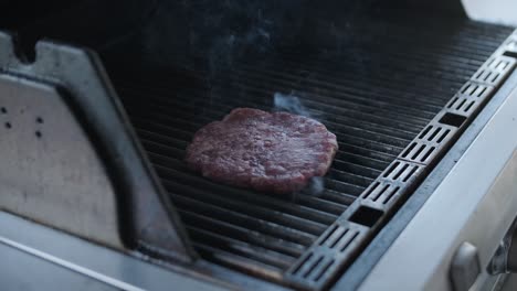 grilled beef patty on bbq grill with smoke