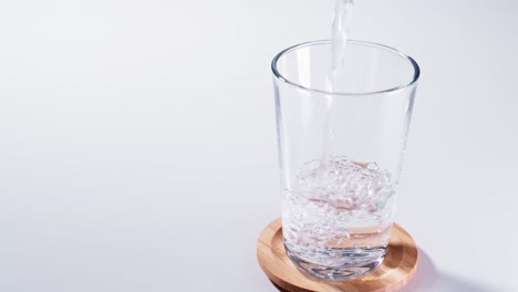 pure water poured into glass closeup with slow motion