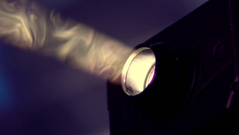 macro of a projector lens beam light with dust particle blured background