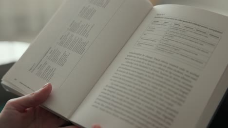 a hand flipping through the pages and perusing a book - close up