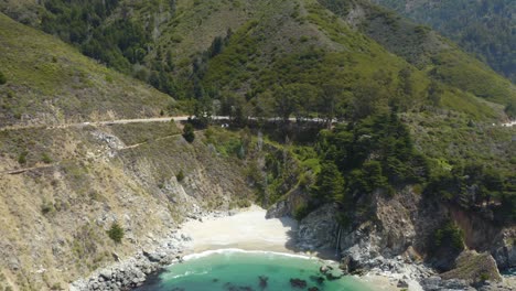 drone descends to reveal panoramic view of famous mcway falls in julia pfeiffer state park along highway 1, california, usa