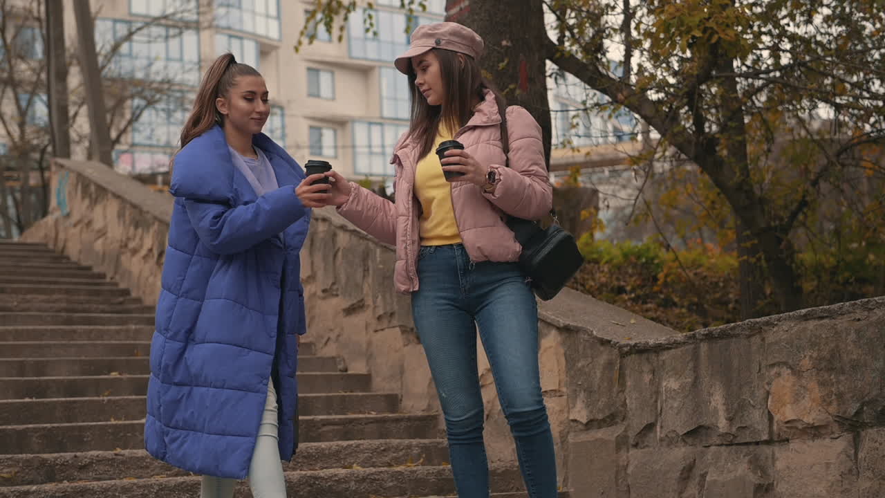 подруги разговаривают и смеются, идя по улице 1