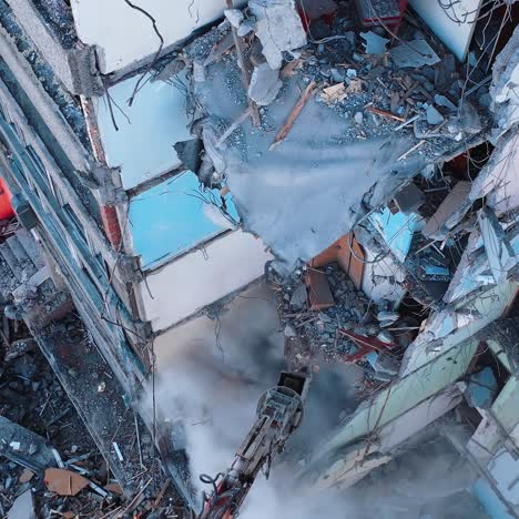 house ruined by the natural disaster being demolished by the excavator. removing the debris of a destroyed building. aerial view