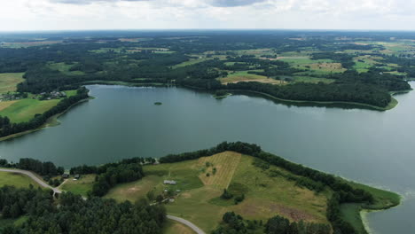 majestic lake and forest flatlands of lithuania, aerial rotate view