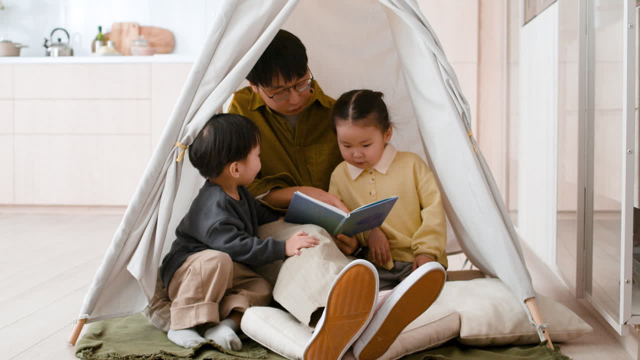 Father Reading to Children in a Play Tent