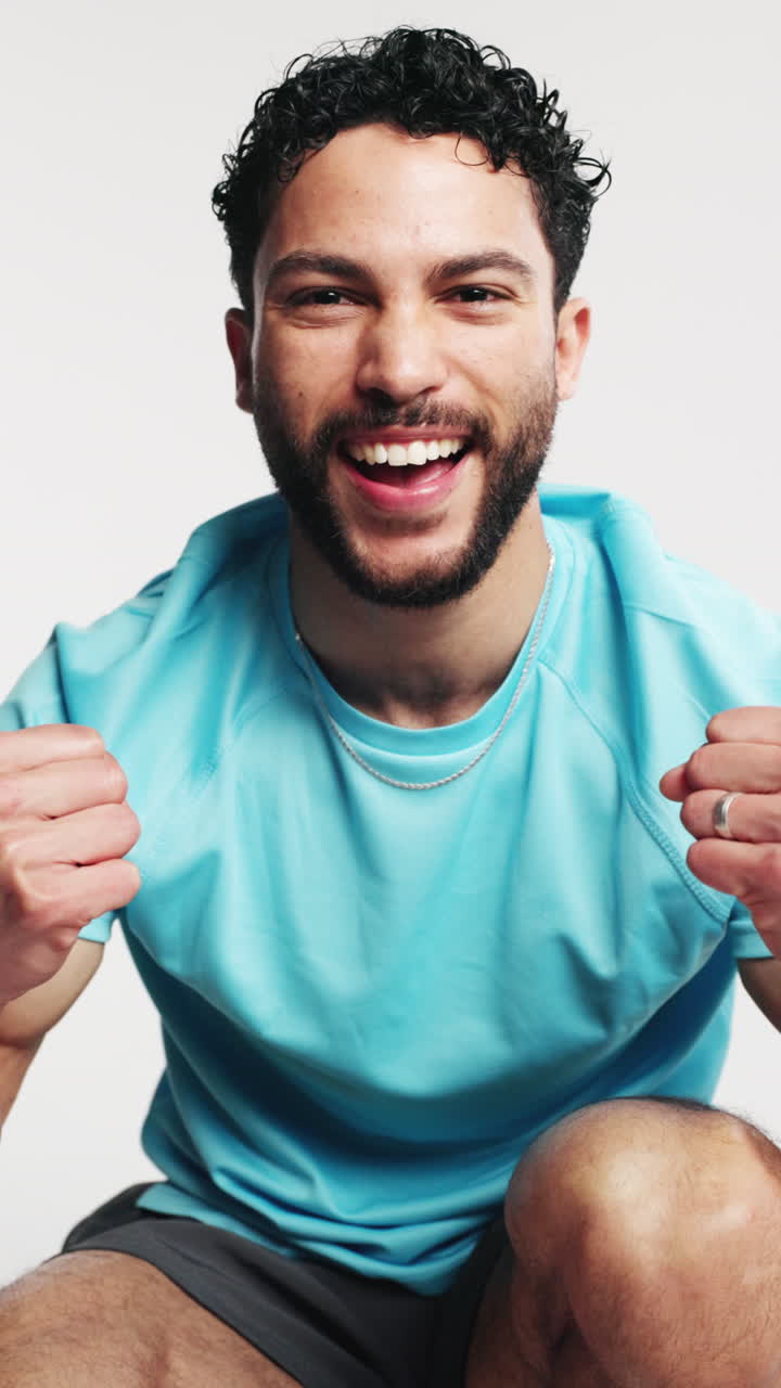 Giovane uomo gioioso che celebra un traguardo in uno studio.