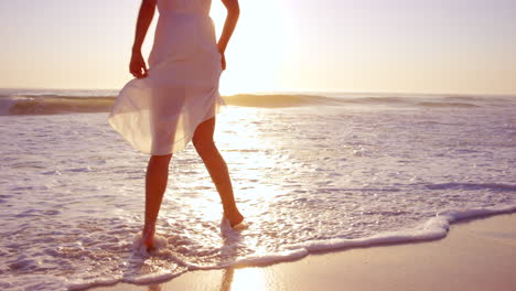 woman walking on beach at sunset