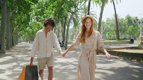 tourist couple walking with shopping bags outdoor. young family holding hands