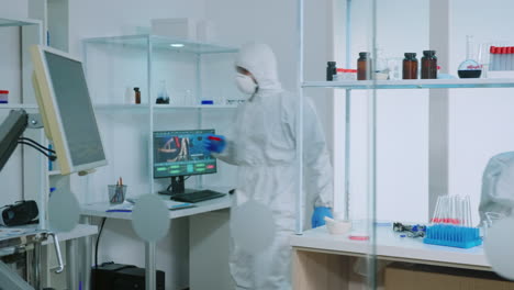 team of scientists in ppe suit analysing test trial vaccine in lab