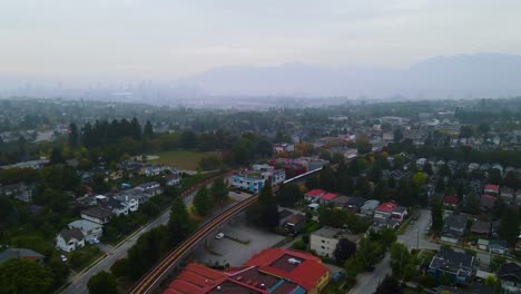 Residential-Outskirts-with-Rail-Train-in-Urban-Vancouver,-BC---Aerial