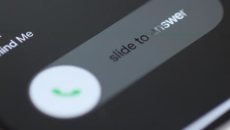 close-up of a smartphone screen showing an incoming call interface with 'slide to answer' message