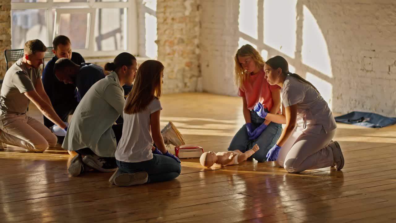 전문적인 여성 의사는 의료진의 의료 훈련 과정 동안 마네킨을 사용하여 공공의 인공 유아 호흡을 가르니다.