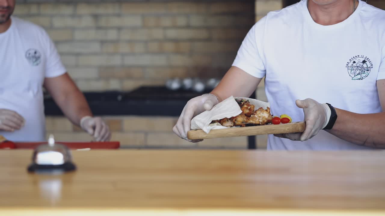 Chef puts the ready meal on the table. Cook putting hot delicious dish and presses the signal. Dinner is ready in the restaurant. Pleasant appetite.