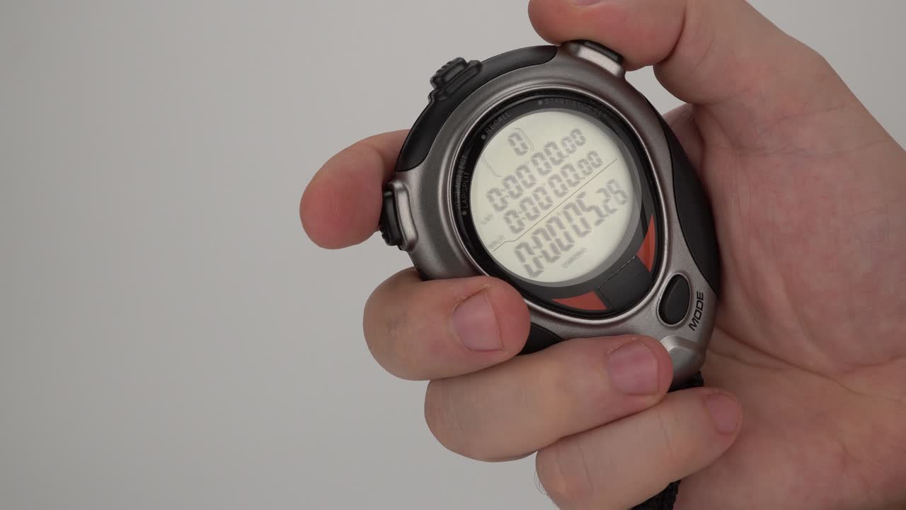 cronómetro deportivo electrónico en la mano de un hombre. lanzamiento del cronómetro electrónico manual. contador de tiempo digital en un fondo blanco. movimiento del tiempo