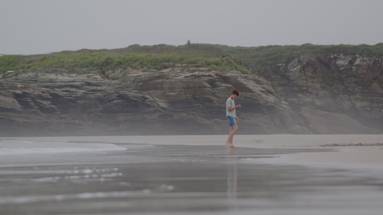 십대 가 안개 가 가득 한 해변 에서 고 있다