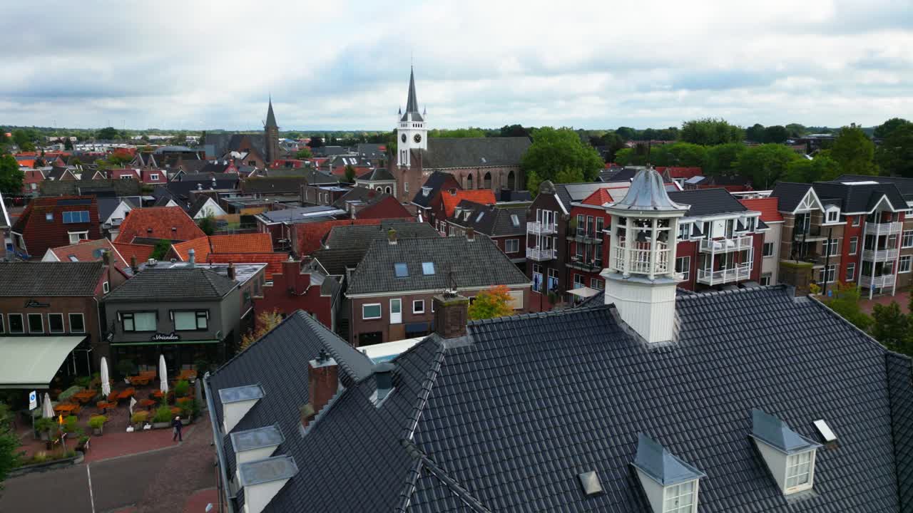 Elevated cityscape of Ommen highlighting tiled rooftops, red brick houses, and church tower with clock. Captured in Ommen, Overijssel, Netherlands (Ommen, Overijssel, Nederland)