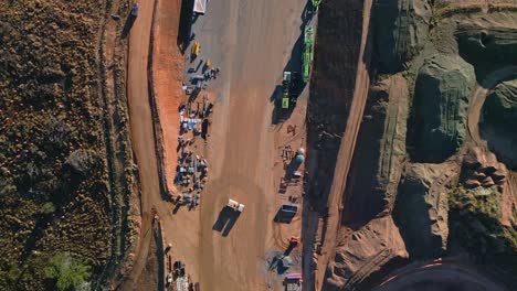 drone footage capturing a highway construction site in canberra, with visible dirt foundations and water trucks actively servicing the area.