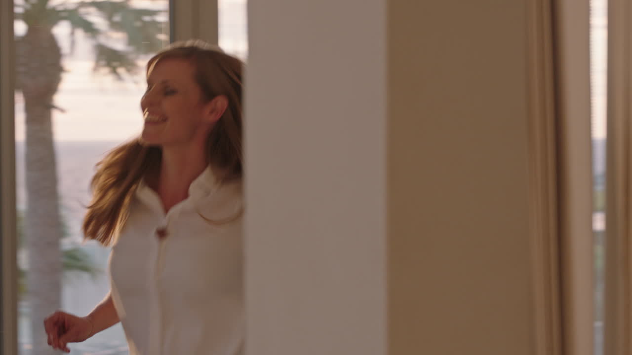 행복한 여행 여성은 호텔 방에서 춤을 추고 즐겁게 여름 휴가를 축하하고 해가 뜨면 무모한 휴가 라이프 스타일을 즐기고 있습니다.