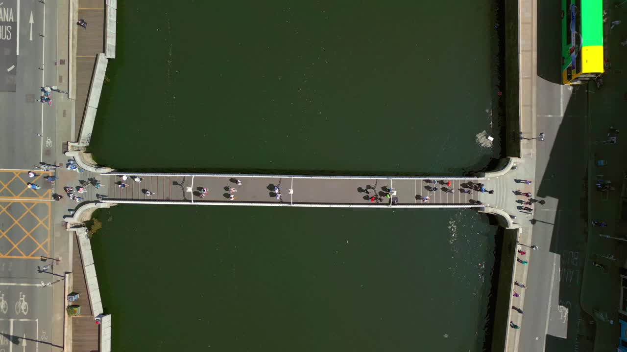 Tight, overhead ascending aerial of the Ha'penny Bridge in Dublin City Centre, Ireland on a bright and sunny day. Filmed in 4K, 60FPS and with Rec709 color.