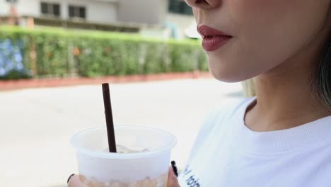 woman drinking iced coffee outdoors