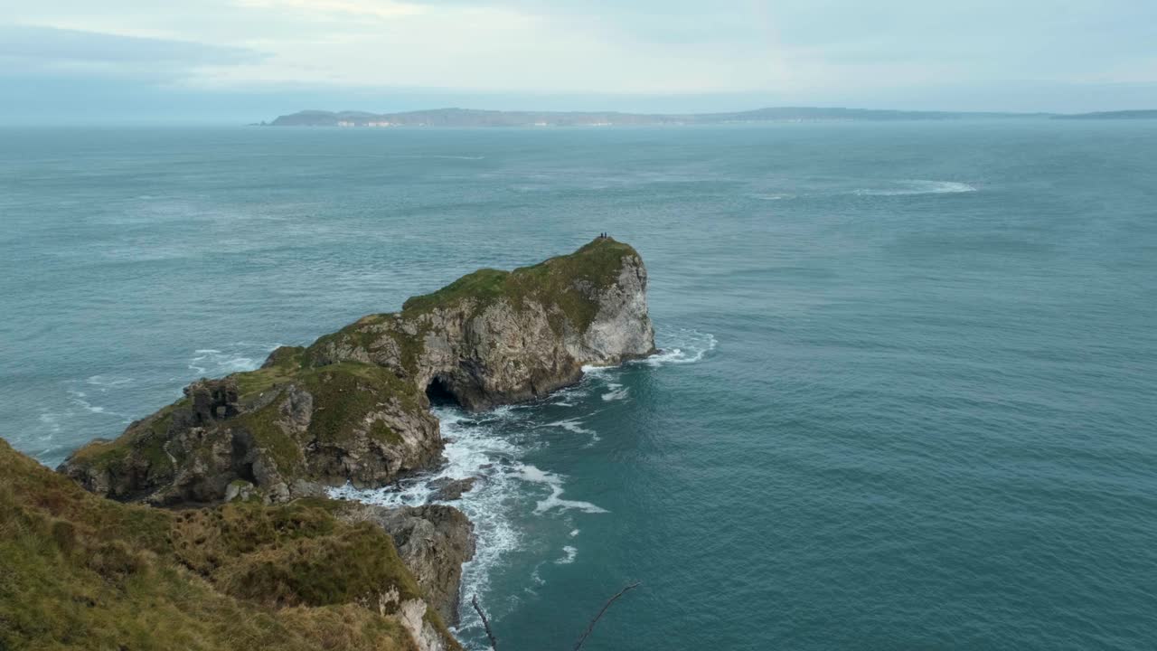 Cold Atlantic waves crash against Ireland’s rugged cliffs under a grey winter sky