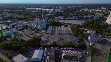 sewage treatment plant in berlin, featuring circular clarifiers, anaerobic digesters, and other wastewater processing infrastructure. nice aerial view flight fly reverse drone