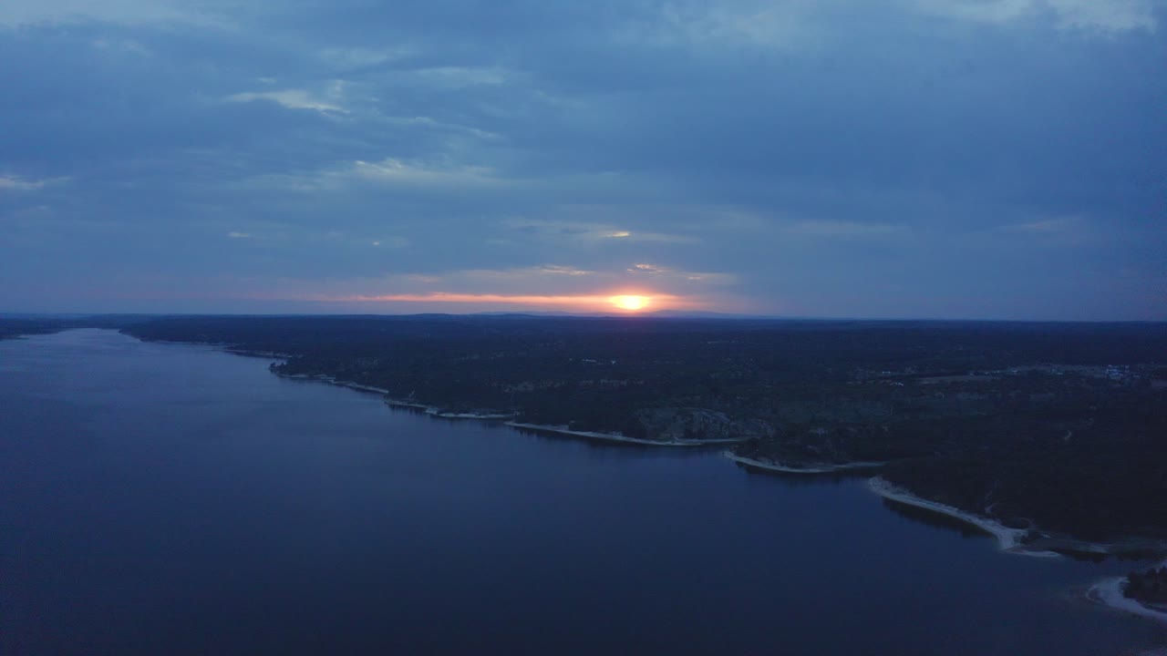Luftfoto af kæmpe solopgang over dæmning i Alentejo, Portugal.