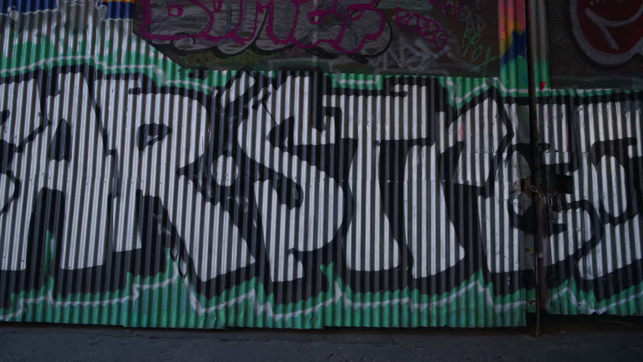 런던 시티 스트리트 1에서 그래피티를 지나가는 젊은 대안 스타일의 여성의 야외 패션