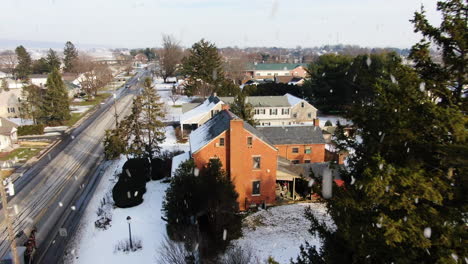 aerial flying over township rooftops during heavy snowstorm