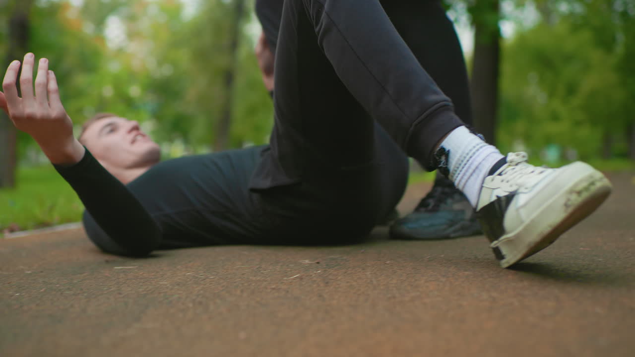 park carry and slam sequence featuring two men on leafy path, aggressive shoulder lift turns into controlled slam and ground collapse, trainerlike demonstration mixed with raw confrontation and quick