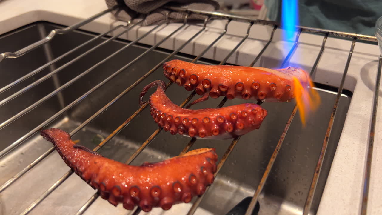 Octopus legs being blow torched with fire, advanced cooking technique, fresh seafood, 4K shot