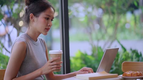 digital nomad millennial gen x lifestyle,asian female freelance casual working from cafe working anywhere work while vacation smiling hand type laptop cheerful positive thinking work remotely in cafe