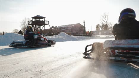 kids go-karting on an ice track in winter