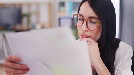 confident businesswoman analyzes documents in office