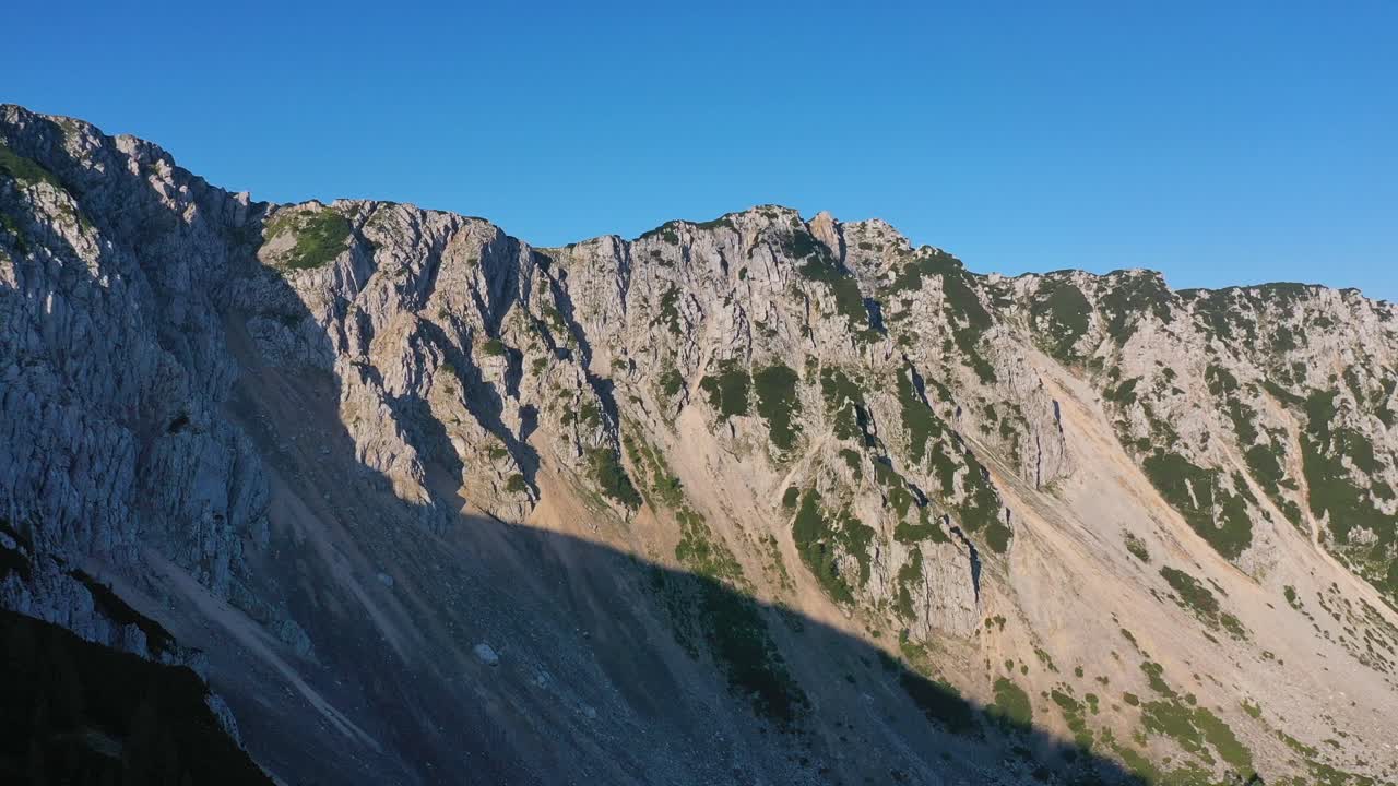 panorámica aérea vista derecha de la cresta de la montaña en austria con pedestal hasta la línea de árboles del bosque