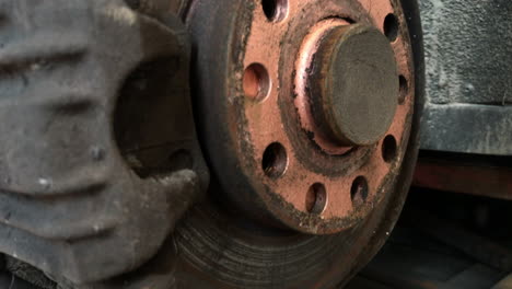 Closeup-shot-of-rusty-used-disc-brake-with-wheel-mounting-holes-covered-by-cooper-grease