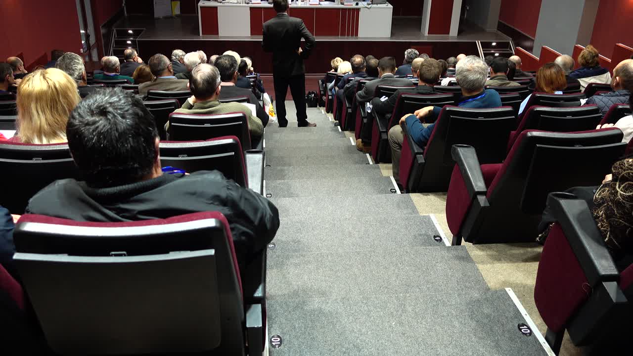 Relatore che si rivolge a un pubblico in un auditorium per conferenze