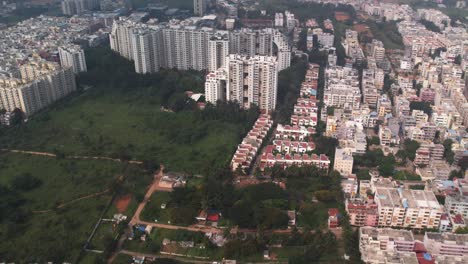 Una-Vista-Aérea-De-Un-Barrio-Residencial-Y-Edificios-Comerciales-Muestra-Un-área-Vacía-Y-Verdosa