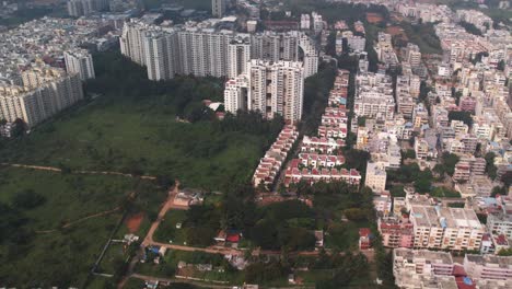una vista aérea con vistas a un vecindario residencial y edificios comerciales muestra un área vacía y verdosa