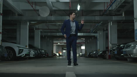 man approaches a his luxury car in a parking garage realizes that he forgot the keys and leaves annoyed