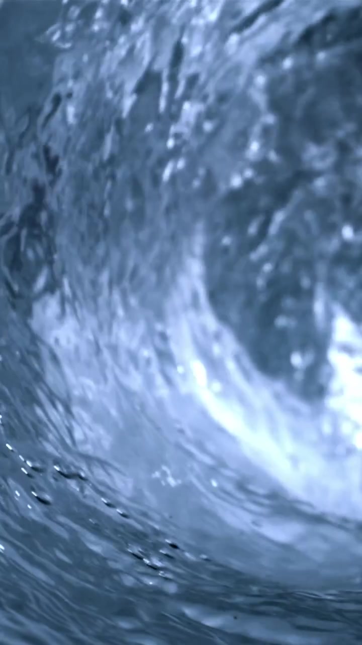 Detailní podvodní záběr vířící modré vody a bublin