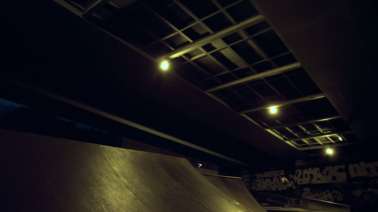 el jinete adolescente de bmx compite en bicicleta en la rampa en el parque de patinaje nocturno.