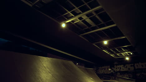 el jinete adolescente de bmx compite en bicicleta en la rampa en el parque de patinaje nocturno.