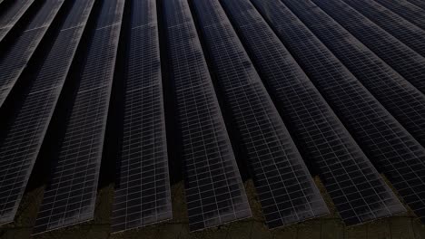 Frozen-solar-panels-aerial-reveal-of-single-turbine-windmill-in-The-Netherlands-part-of-sustainable-industry-in-Dutch-river-IJssel-landscape-near-Zutphen