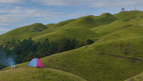 camping on lush green hills of sailung, dolakha, nepal, with a cozy bonfire beside the tent
