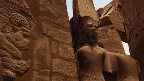 large stone statue of an egyptian pharaoh at karnak temple in luxor, egypt. ancient ruins and historic sculpture from the temple site