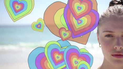 animation of colourful hearts over portrait of caucasian woman on beach