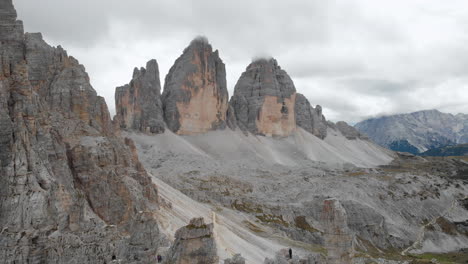 Toma-Aérea-De-Un-Dron-Sobre-Un-Modelo-Masculino-Mirando-Tre-Cime-Di-Lavaredo-En-Los-Dolomitas,-Italia