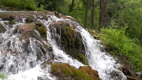 agua que fluye sobre una formación rocosa cubierta de musgo en el parque nacional krka en croacia a ¼ de velocidad